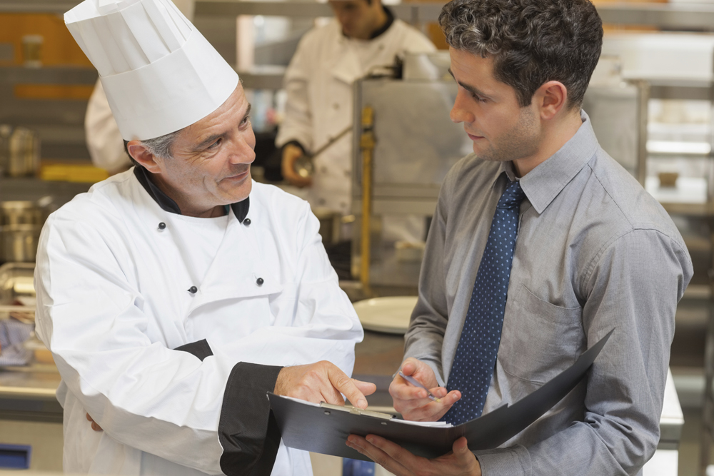 Chef in commercial kitchen with staff