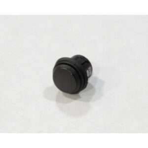 A small, round, black push button switch—ideal for devices like an automatic grease removal system—is shown on a plain, light-colored surface. The plastic button features a simple, utilitarian design.