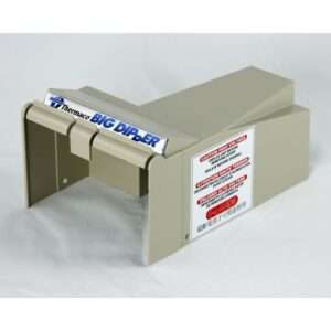 A beige Thermaco Big Dipper automatic oil and grease separator with warning and instruction labels is shown on a plain white surface. The self-cleaning grease trap features a rectangular shape with a slot and signage on the front.